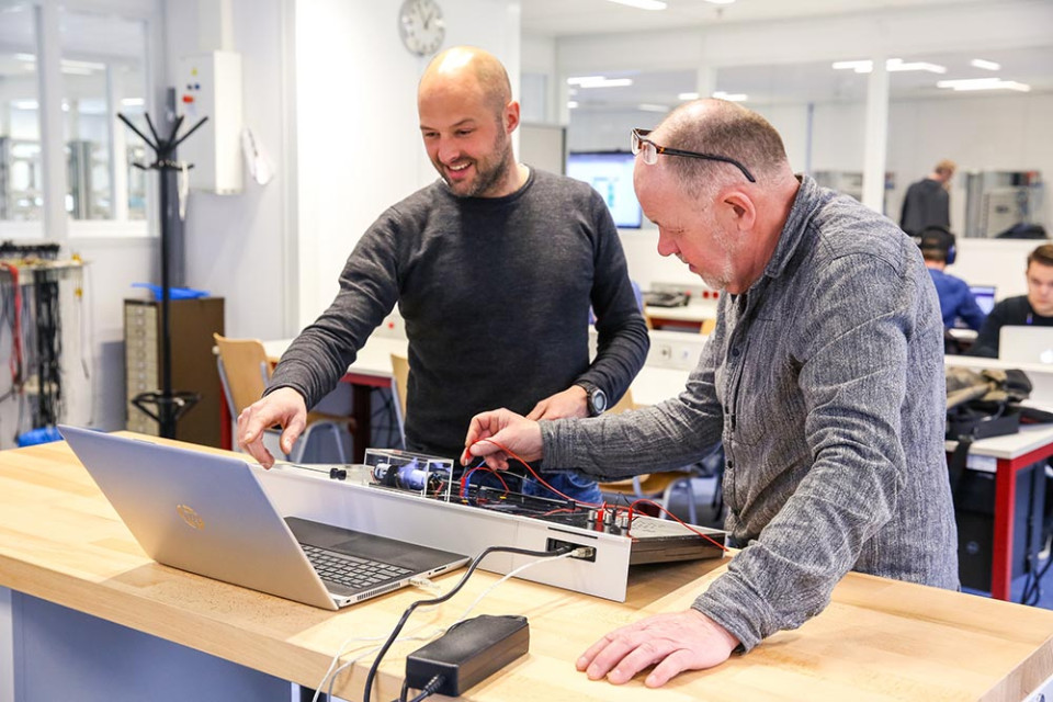 Twee mannen aan het werk achter een computer.