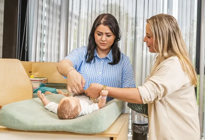 Twee studenten verschonen een babypop