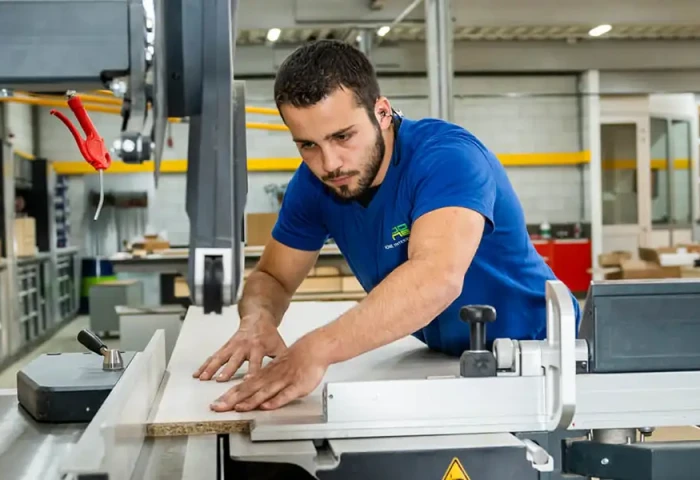 Man zaagt een plank aan een tafelzaagmachine