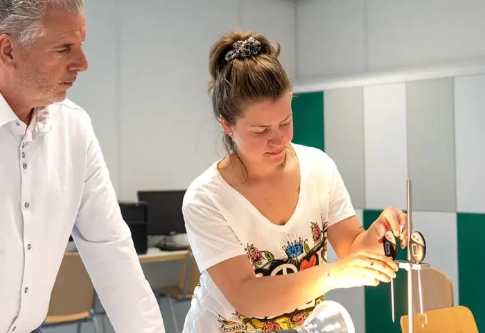 Docent en student werken in een klas aan een project