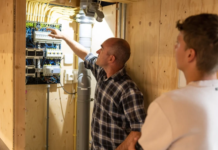 Student en docent staan aan een schakelkast.