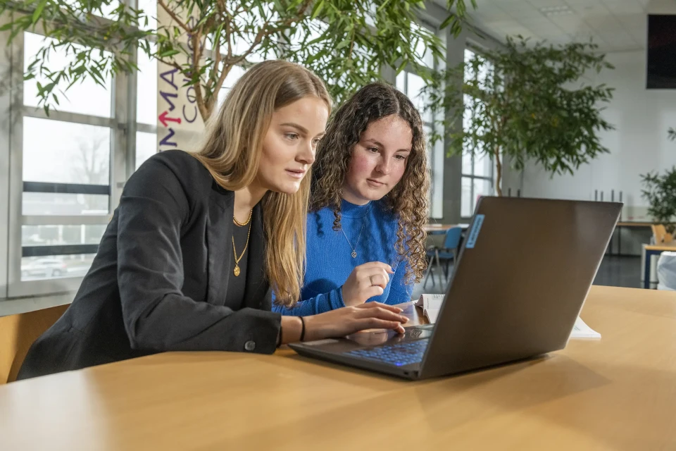 Twee studenten werken aan één laptop
