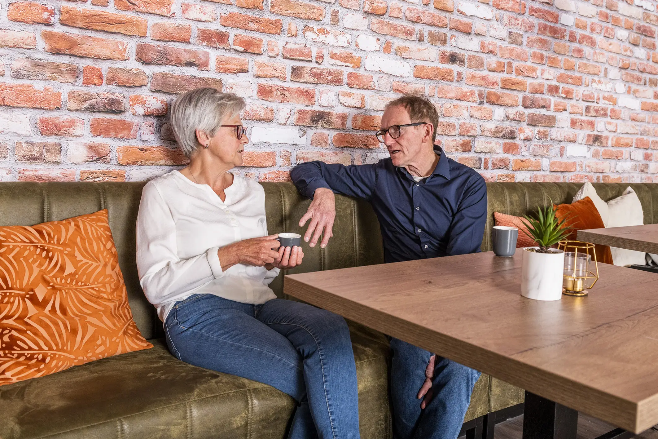 A man and a woman are sitting at a table and discussing