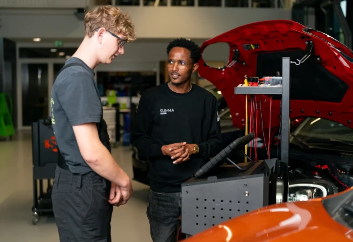 Docent en instructeur bij een werkstuk in de werkplaats.